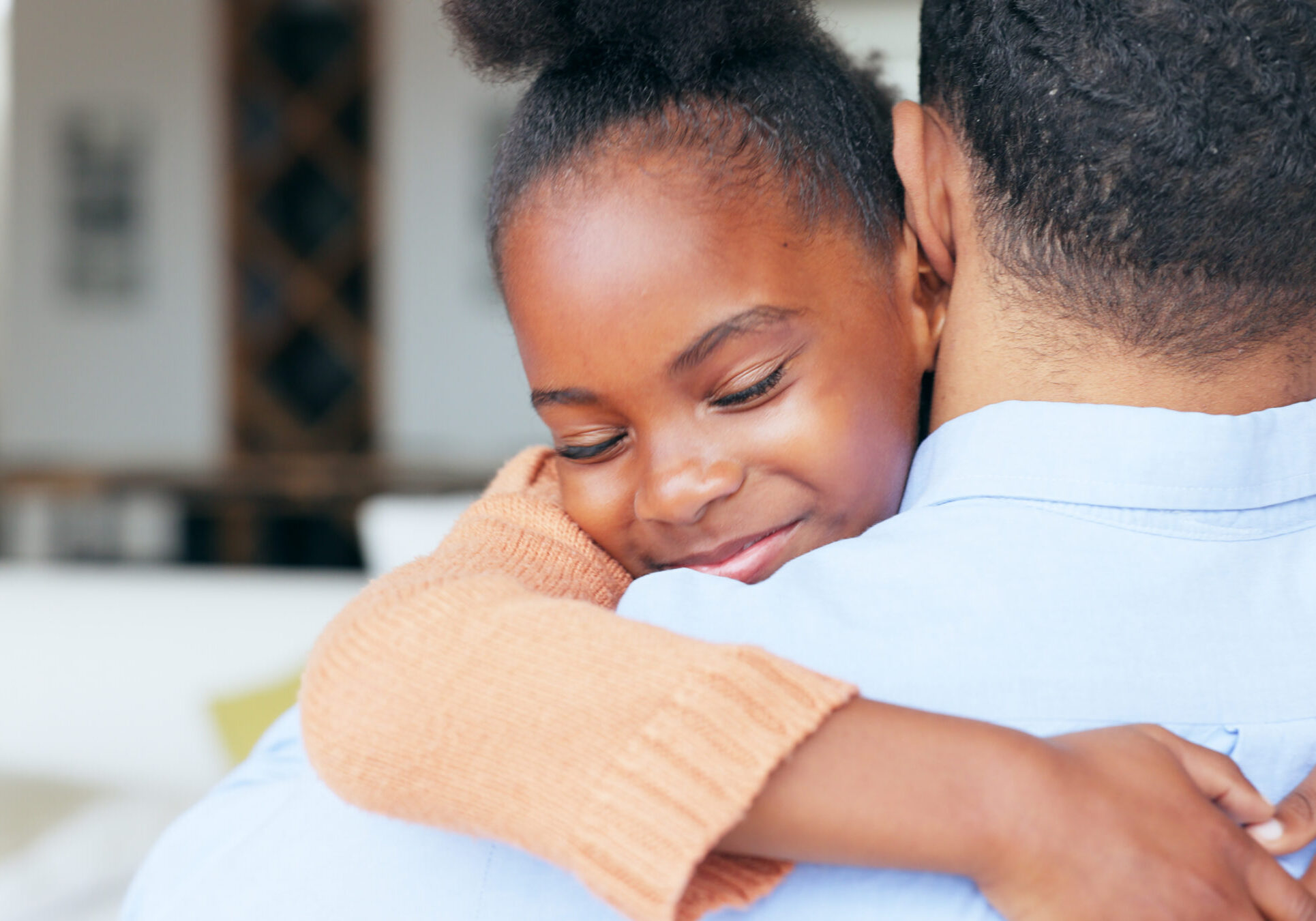 Girl, father and hug in closeup, back and family home with welcome, reunion and smile with love in living room. African daughter, dad and embrace with care, happy and bonding in lounge at apartment Girl, father and hug in closeup, back and family home with welcome, reunion and smile with love in living room. African daughter, dad and embrace with care, happy and bonding in lounge at apartment.